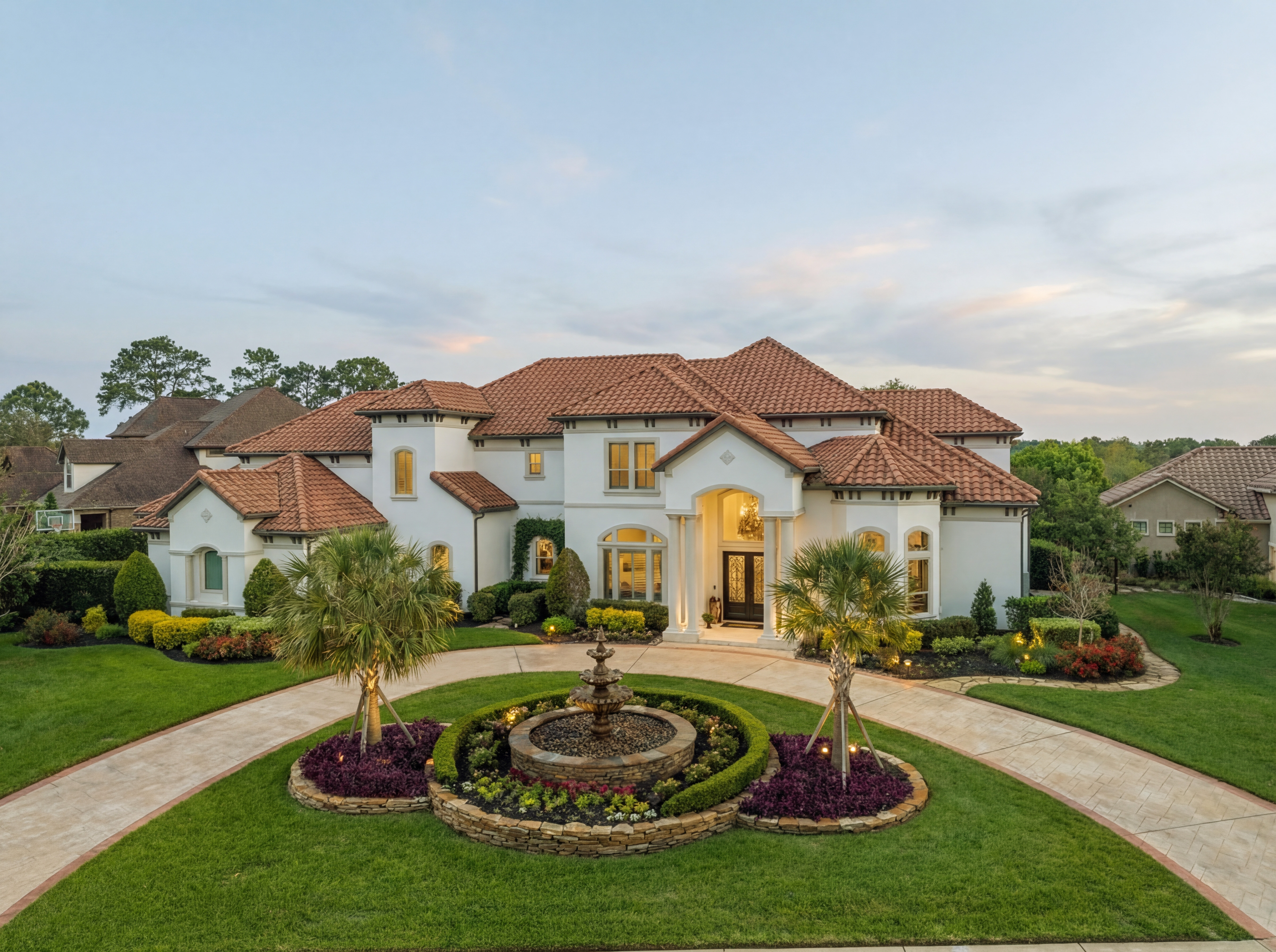 a view of a white house with a big yard and potted plants