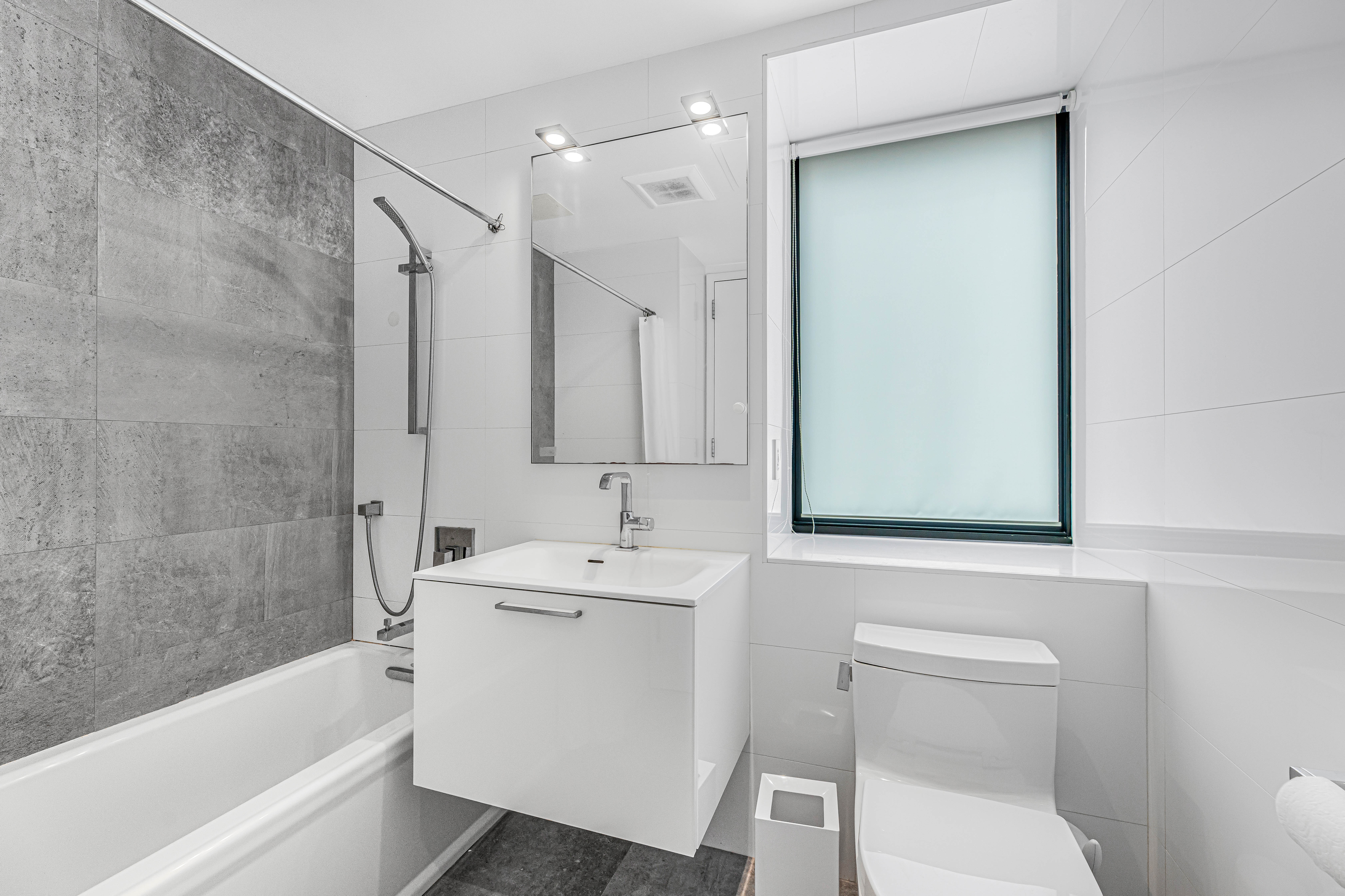 42-50 27th Street, Unit 9C Queens, NY 11101 - Photo 6 of 32 a bathroom with a sink a toilet and shower