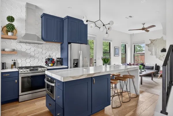 a kitchen with stainless steel appliances granite countertop a sink stove and cabinets