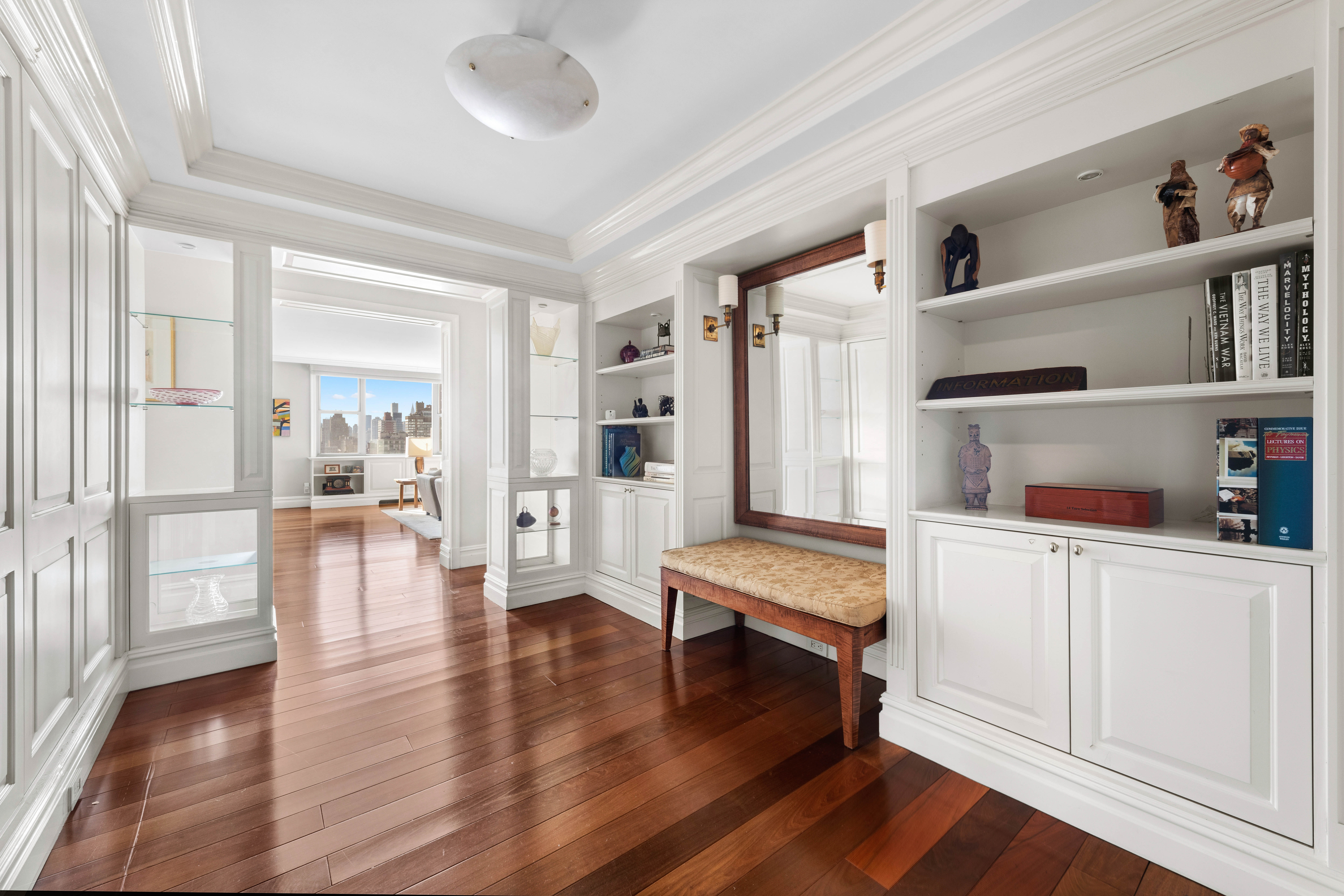444 East 86th Street, Unit 25EF Manhattan, NY 10028 - Photo 10 of 18 a hallway with wooden floor and book shelf