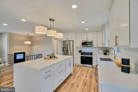 a kitchen with stainless steel appliances a stove sink microwave and cabinets
