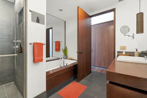 a bathroom with a tub sink and mirror