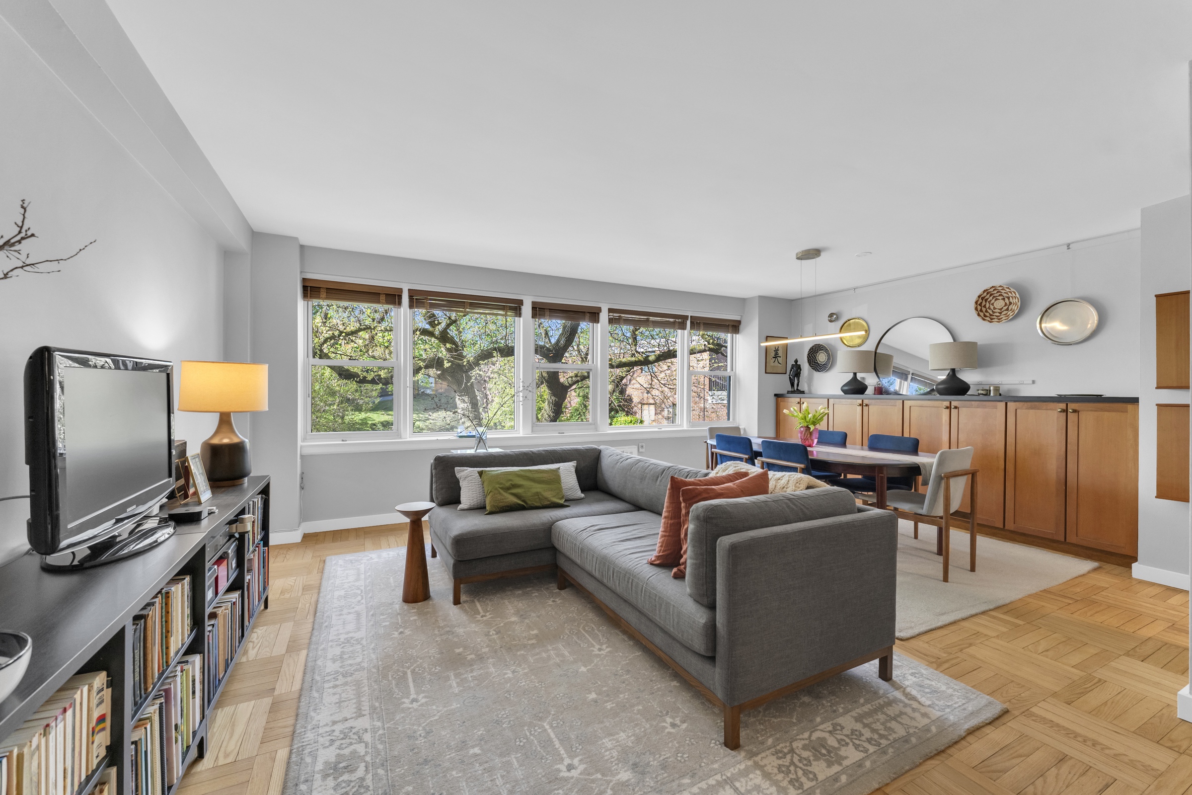 4555 Henry Hudson Parkway West, Unit A310 Bronx, NY 10471 - Photo 1 of 16 a living room with furniture and a flat screen tv