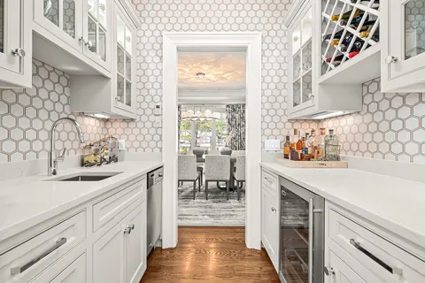 a kitchen with white cabinets and wooden floor