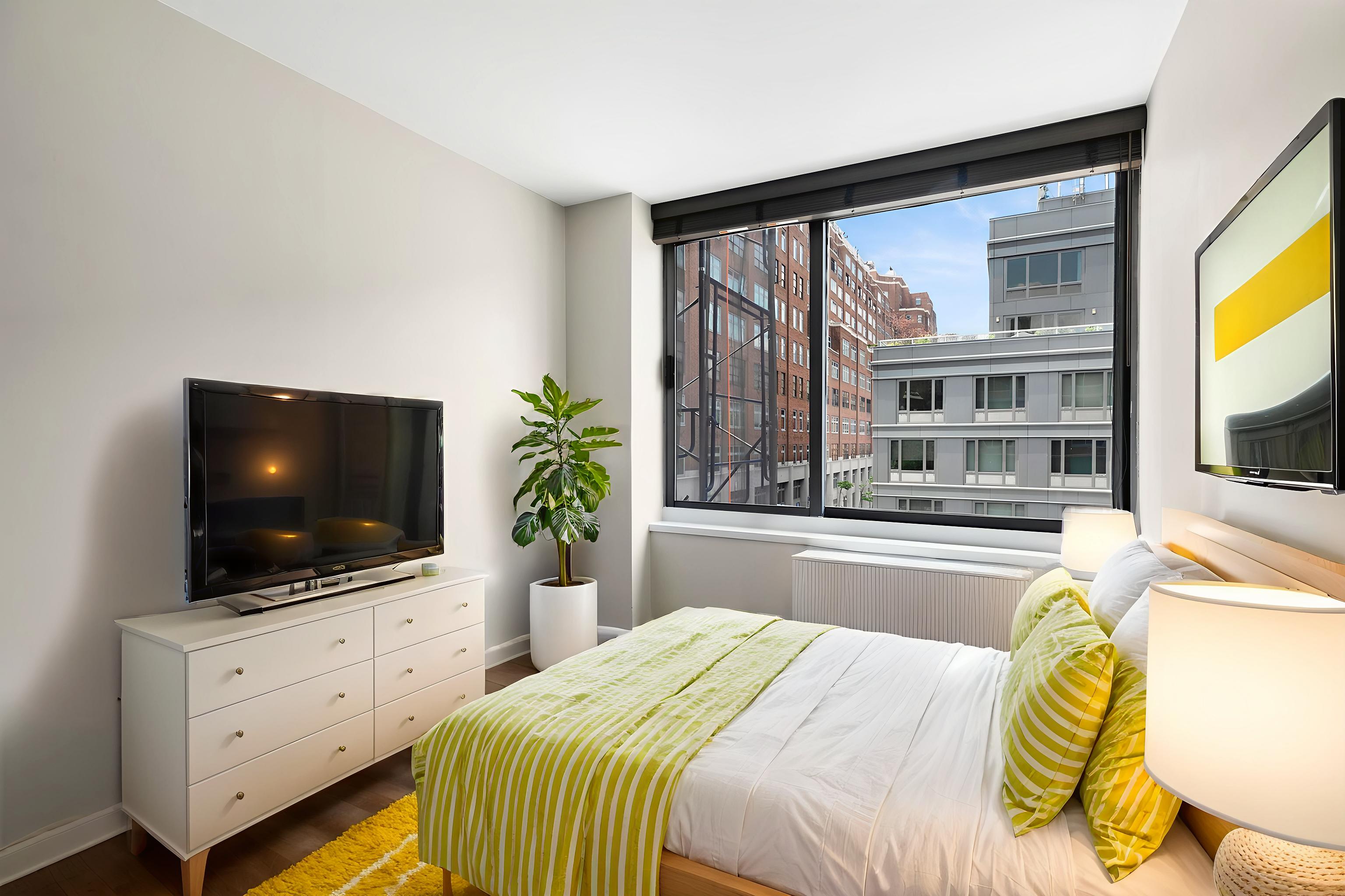 270 West 17th Street, Unit 4L Manhattan, NY 10011 - Photo 5 of 11 a bedroom with a flat screen television and a bed