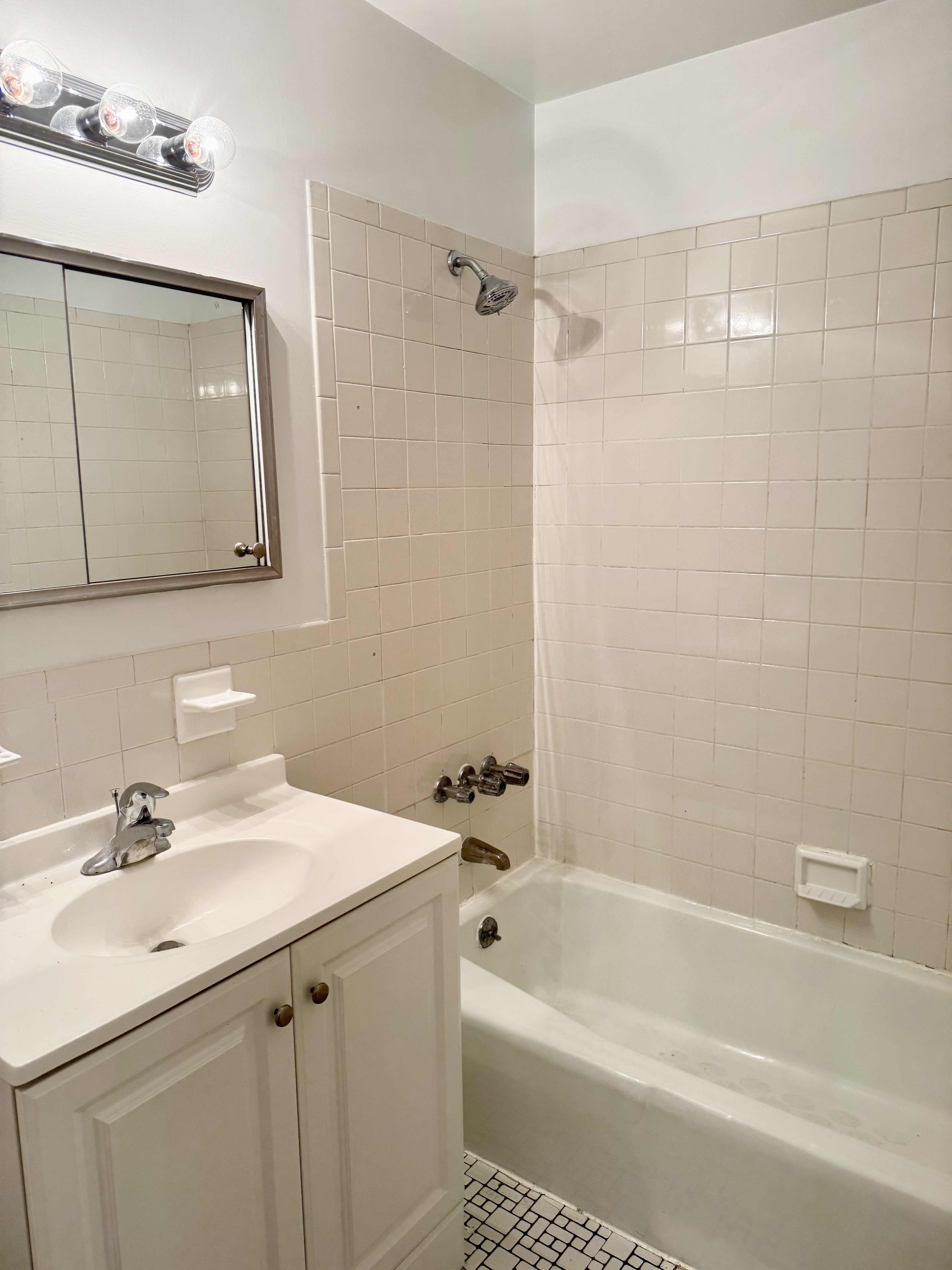 59-15 39th Avenue, Unit 2 Queens, NY 11377 - Photo 6 of 13 a bathroom with a tub a sink and mirror