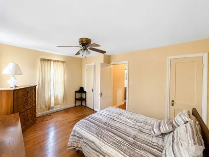 a bedroom with a bed and wooden floor