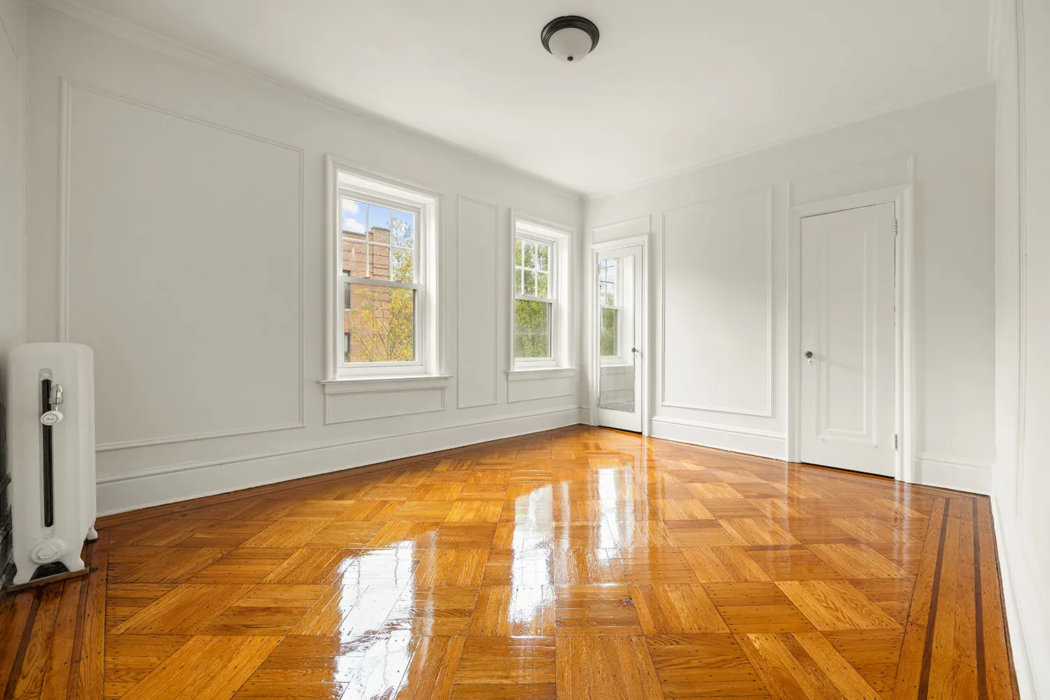 a view of an empty room with window and a kitchen