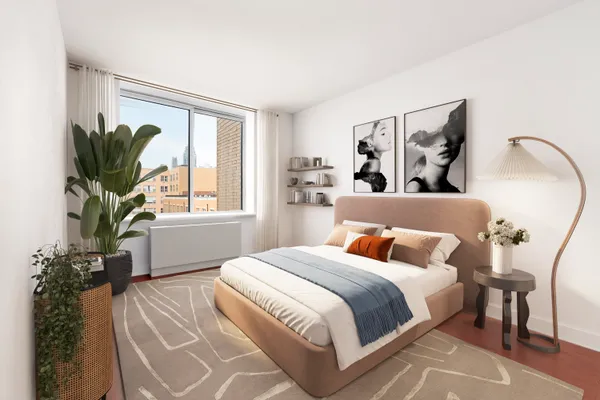 a bedroom with a large bed and a potted plant