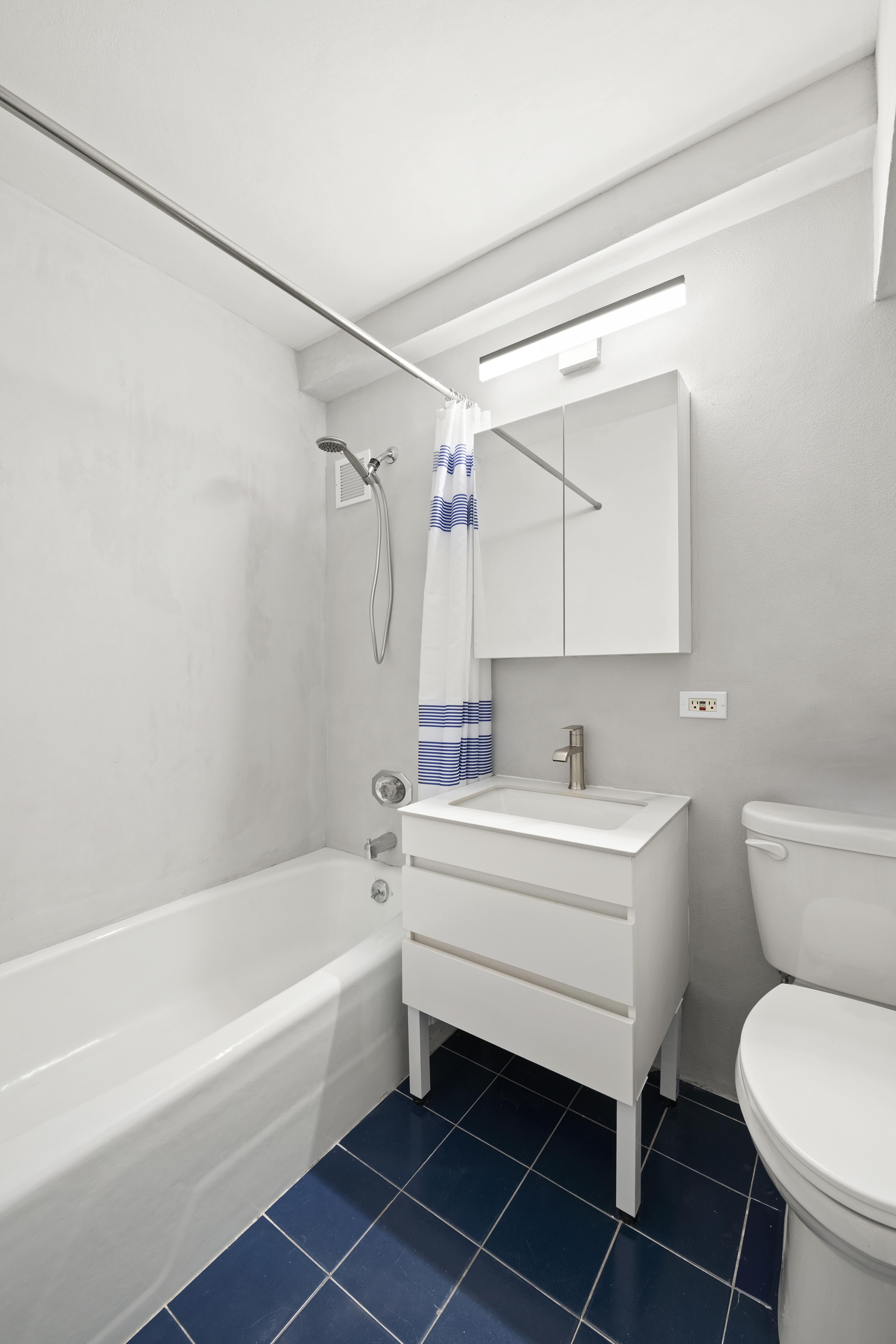 315 West 23rd Street, Unit 3E Manhattan, NY 10011 - Photo 4 of 10 a bathroom with a sink toilet a bathtub and a shower