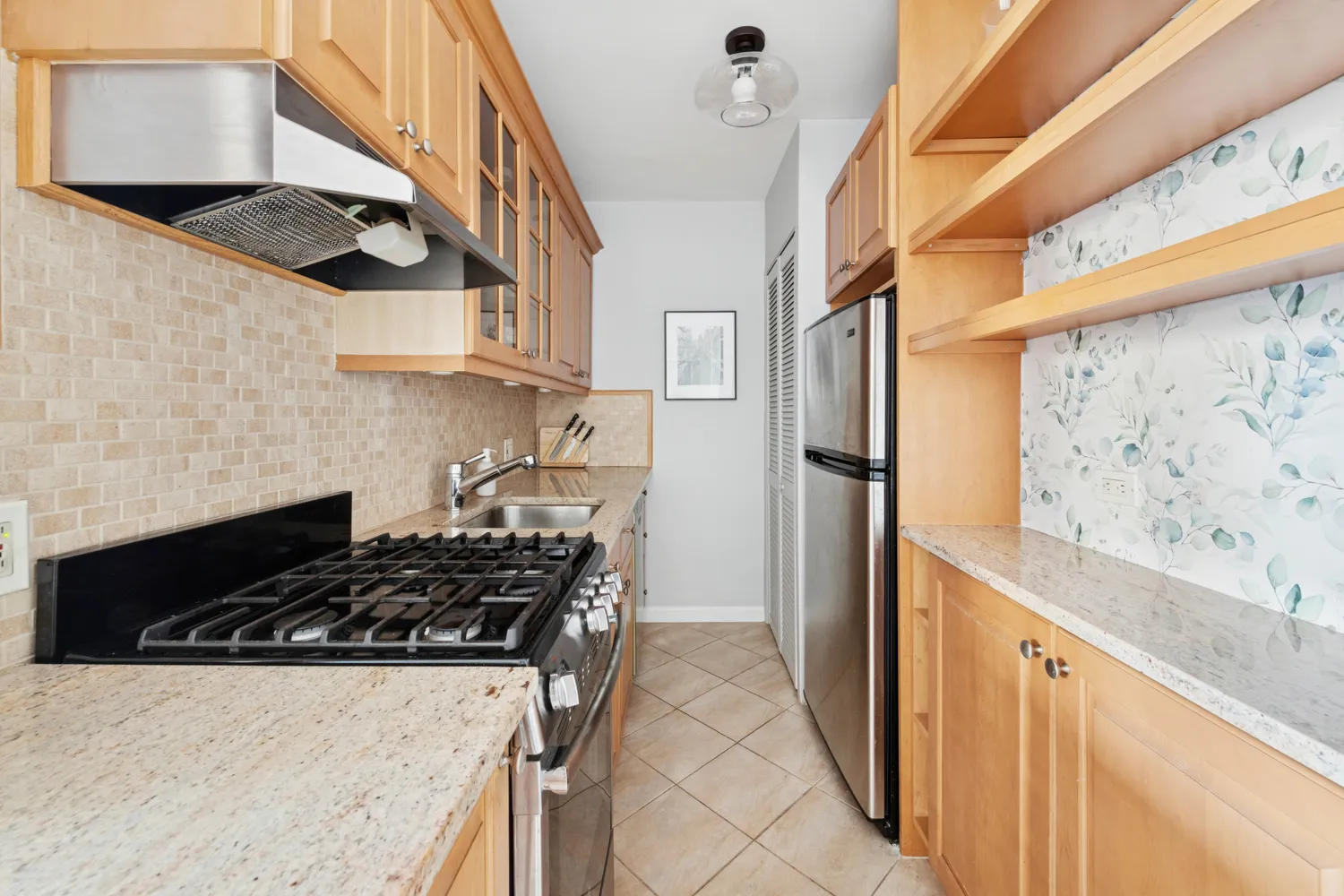 a kitchen with stainless steel appliances granite countertop a stove and a refrigerator