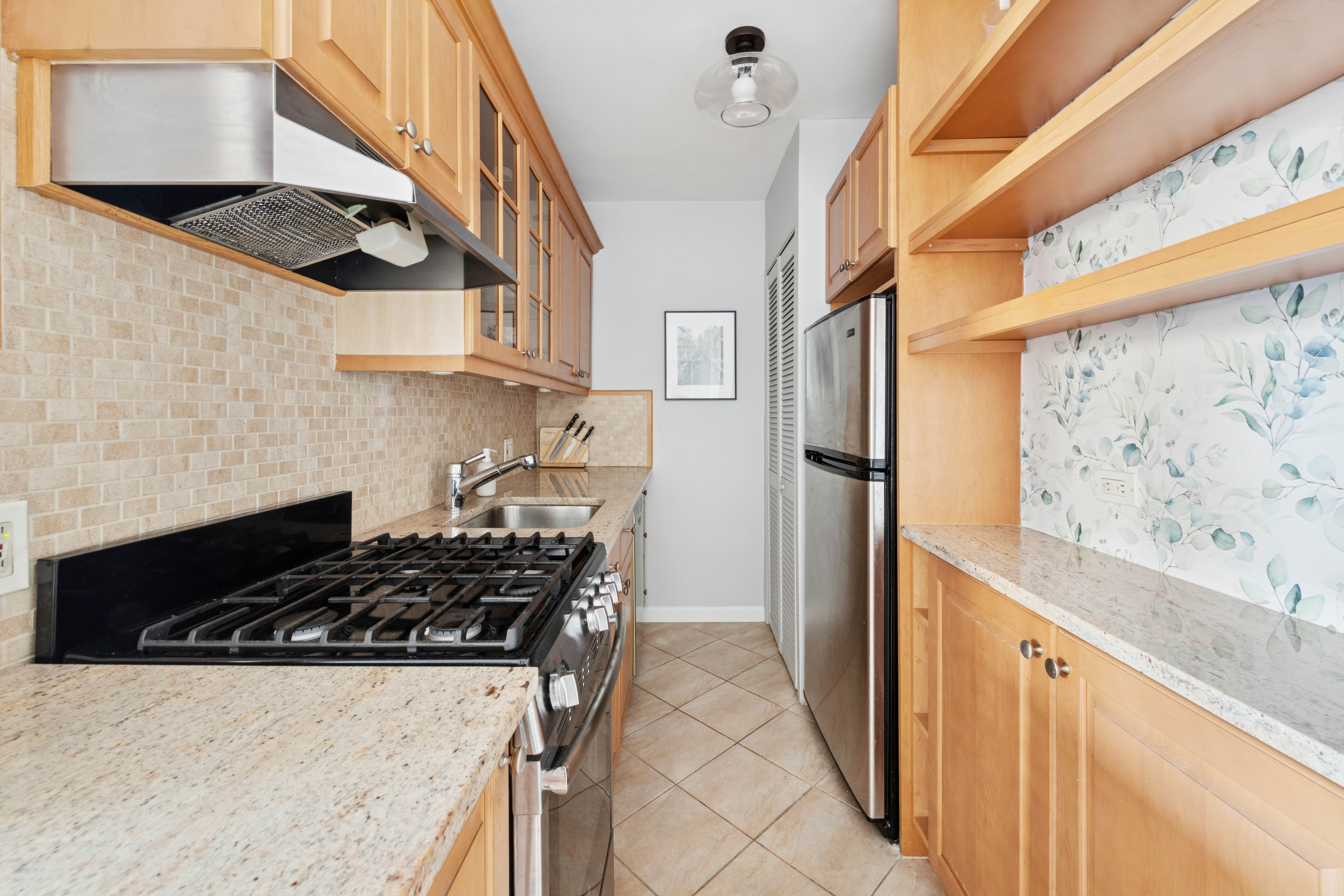 363 East 76th Street, Unit 11K Manhattan, NY 10021 - Photo 7 of 16 a kitchen with stainless steel appliances granite countertop a stove and a refrigerator
