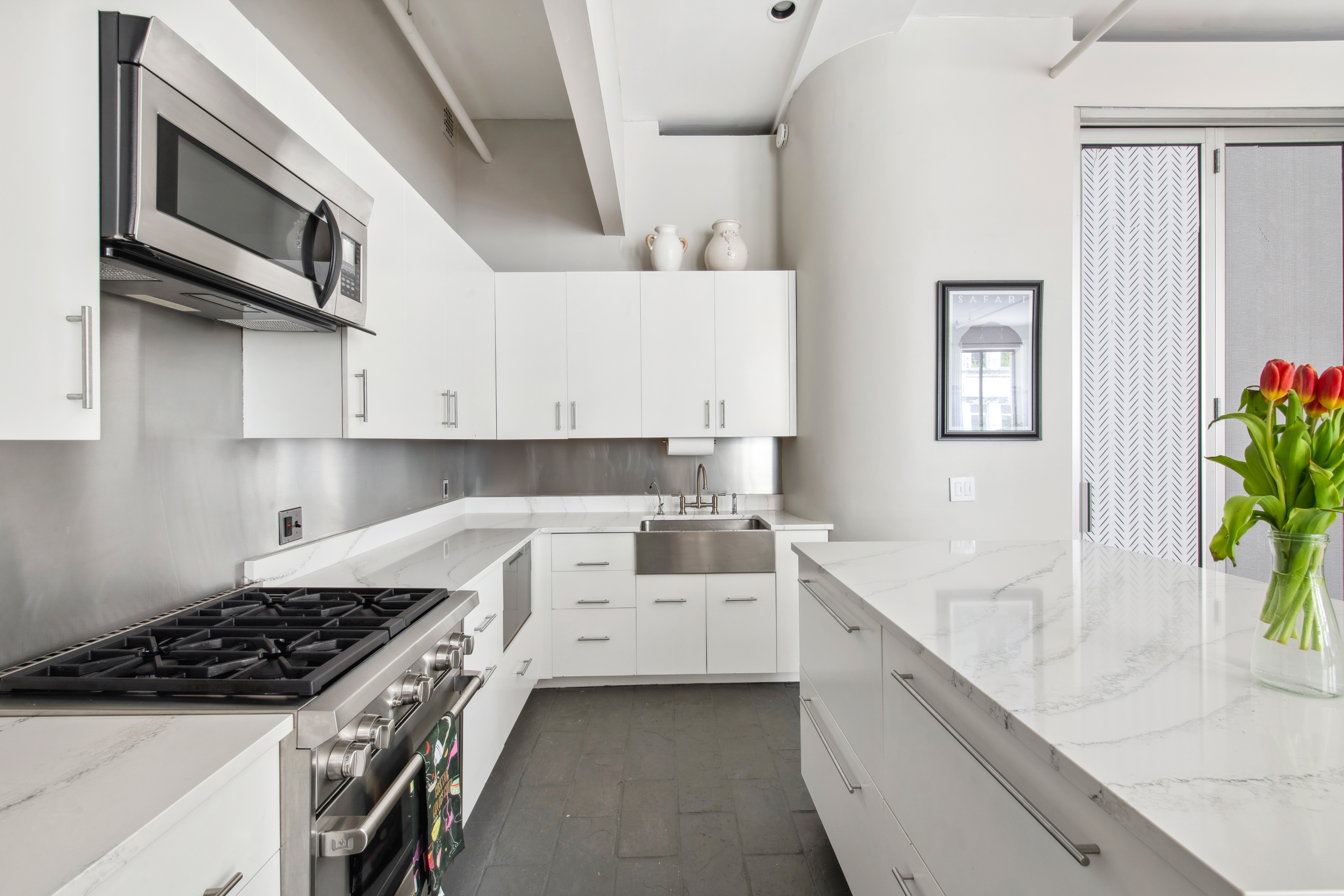 112 West 18th Street, Unit 2A Manhattan, NY 10011 - Photo 3 of 10 a kitchen with a sink stove and cabinets