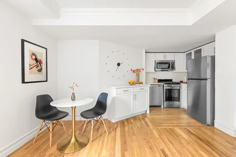 a kitchen with granite countertop cabinets a refrigerator and a stove top oven