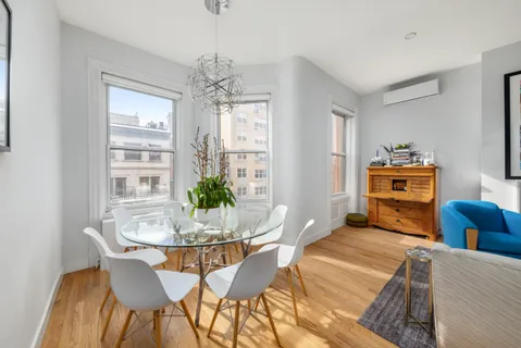a dining room with furniture a chandelier and wooden floor