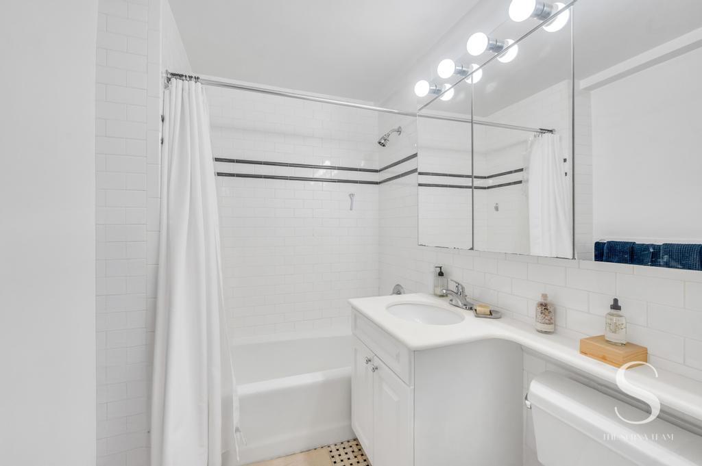 7 Lexington Avenue, Unit 5E Manhattan, NY 10010 - Photo 21 of 27 a bathroom with a sink vanity tub and shower