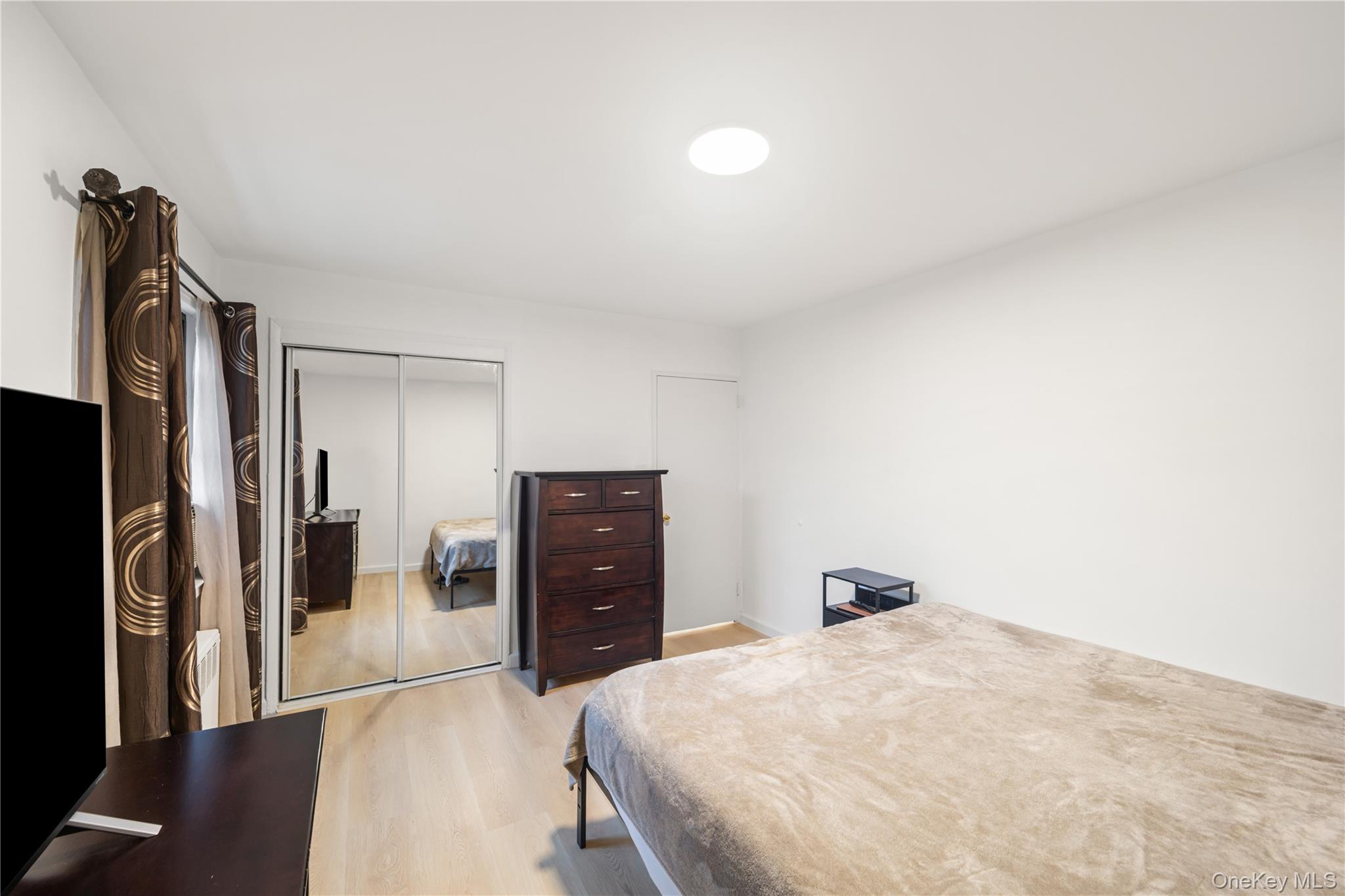 217-14 73rd Avenue, Unit 1 Queens, NY 11364 - Photo 10 of 19 a bedroom with a bed and a dresser