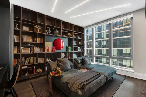 a bedroom with bed and a book shelf
