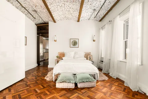 a bedroom with a bed and a mirror