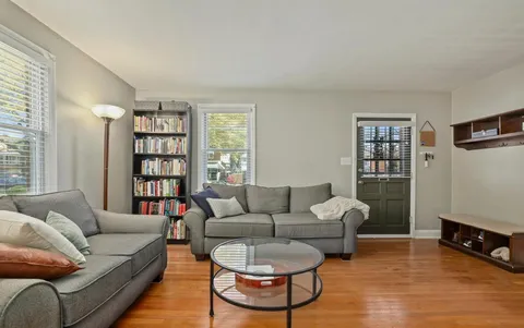 a living room with furniture a rug and a window