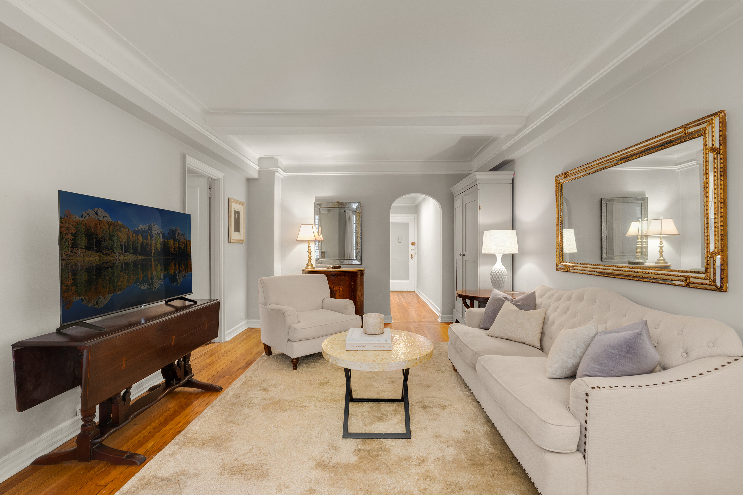 227 East 57th Street, Unit 2H Manhattan, NY 10022 - Photo 4 of 9 a living room with furniture and a flat screen tv
