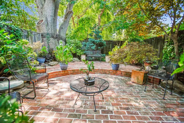 a backyard of a house with fountain table and chairs
