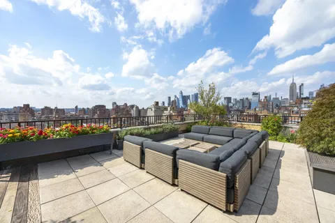 a view of a roof deck with couches and night view