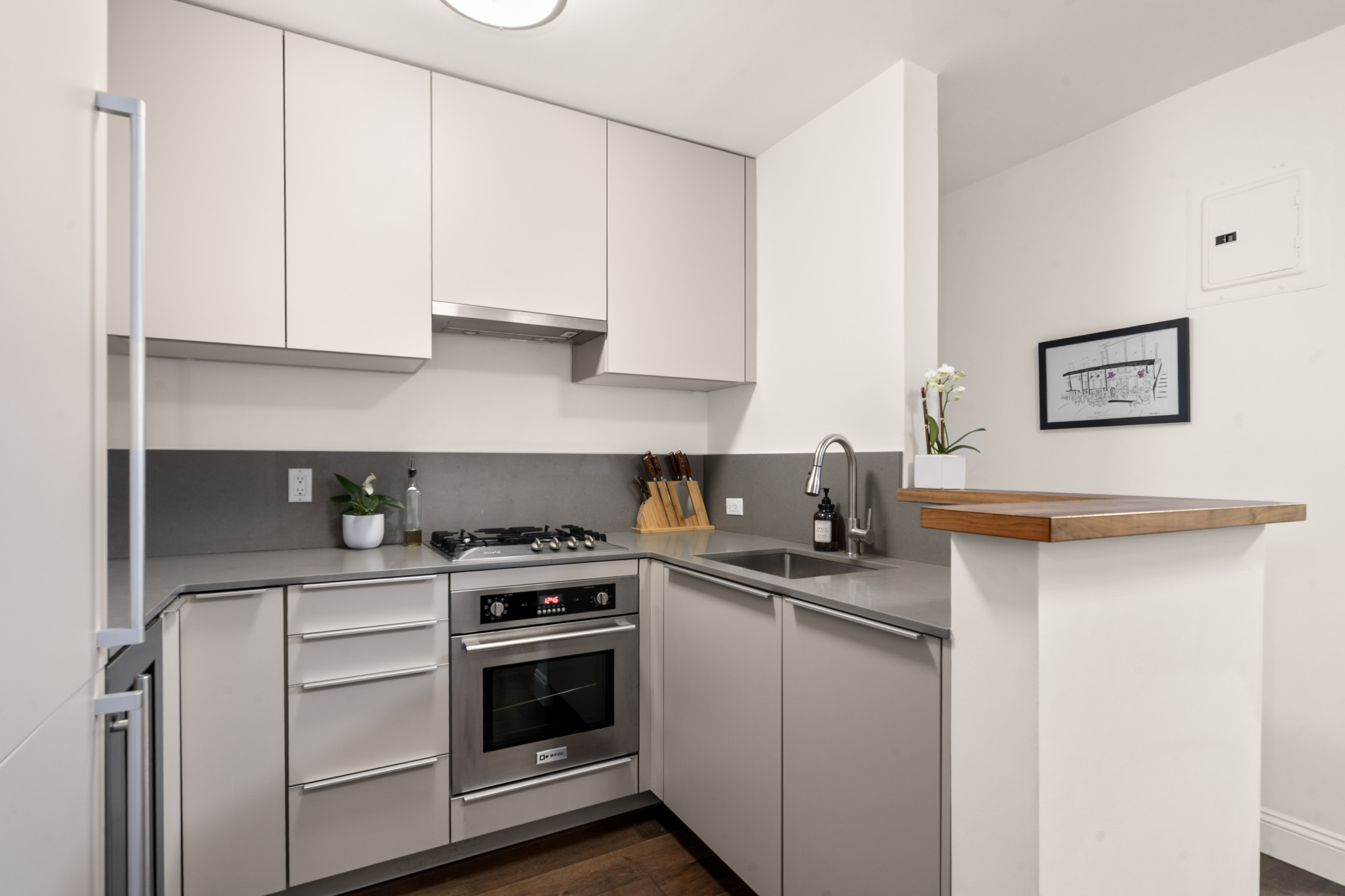 100 Bank Street, Unit 1A Manhattan, NY 10014 - Photo 3 of 6 a kitchen with white cabinets and appliances