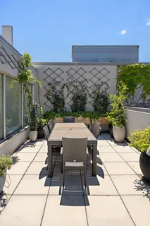 a view of a patio with table and chairs potted plants with wooden floor