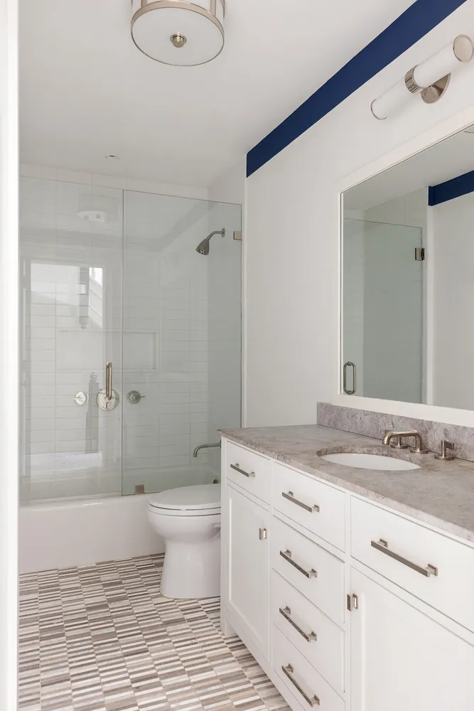 a bathroom with a granite countertop sink toilet and shower