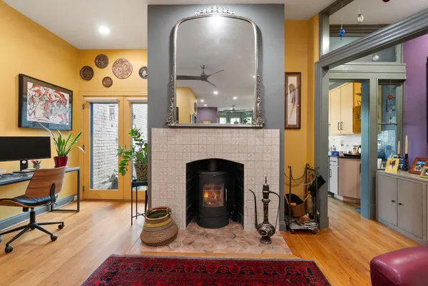 a kitchen with stainless steel appliances granite countertop a stove a refrigerator a sink a dining table and chairs with wooden floor