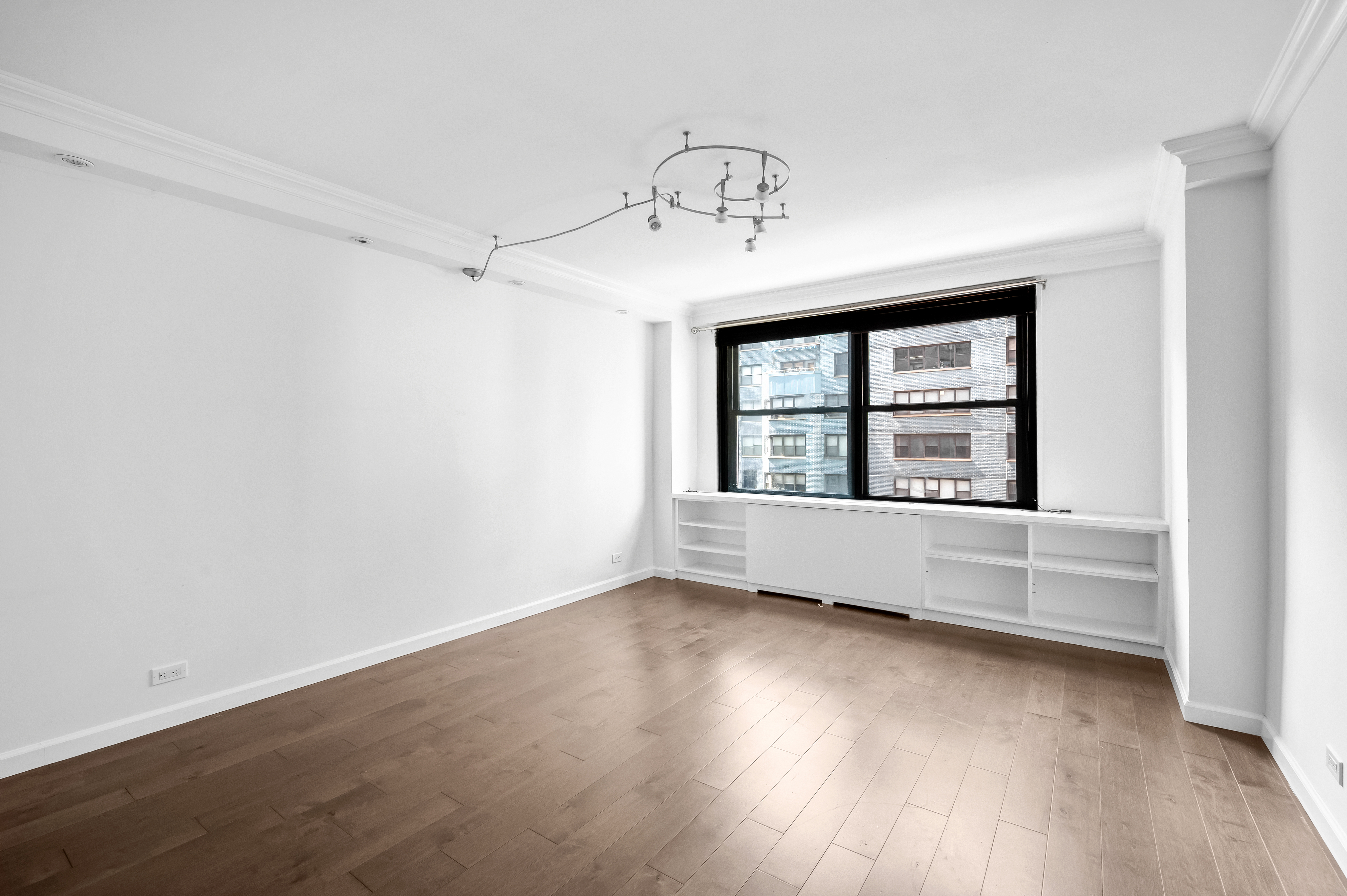 225 East 57th Street, Unit 14F Manhattan, NY 10022 - Photo 7 of 14 an empty room with wooden floor and windows