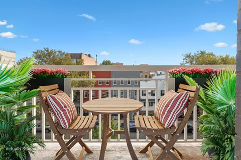 a view of a city from a dining room with furniture and a floor to ceiling window