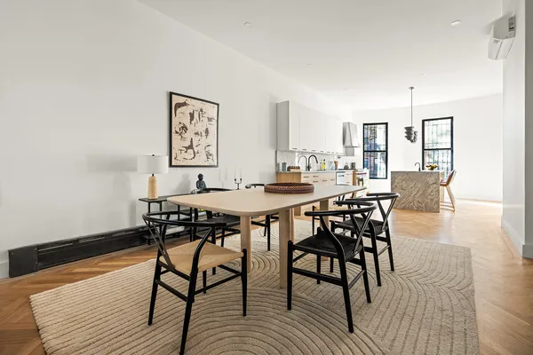 a dining room with chandelier and wooden floor