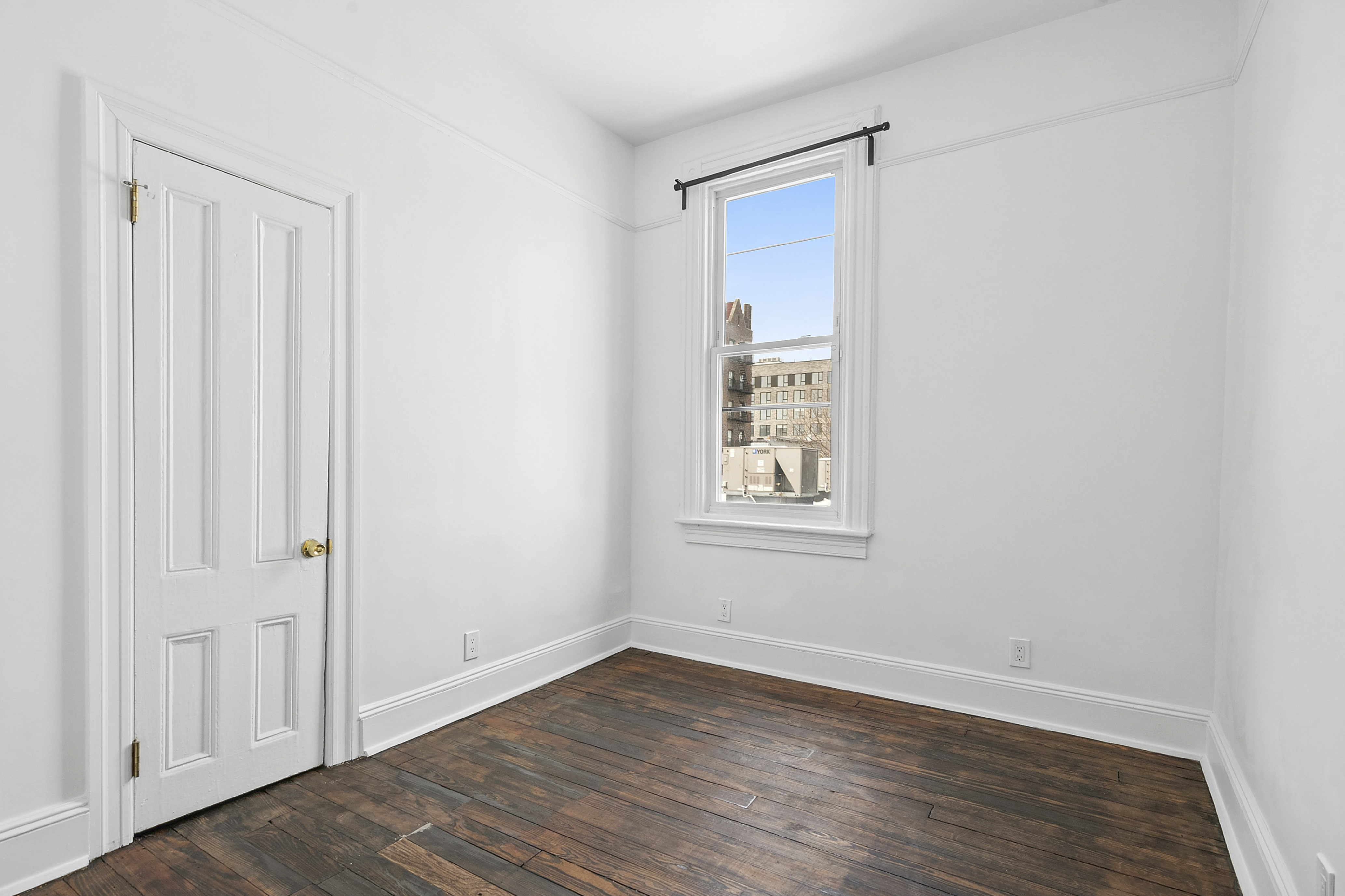 239 East 23rd Street, Unit 2 Brooklyn, NY 11226 - Photo 4 of 8 an empty room with wooden floor and windows