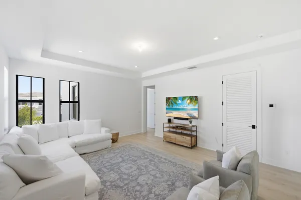 a spacious bedroom with a bed a couch and potted plant