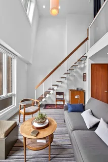 a living room with furniture and a dining table with wooden floor