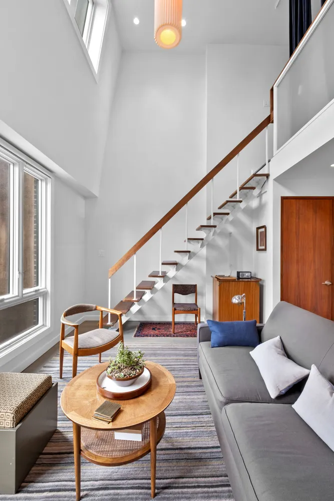 a living room with furniture and a dining table with wooden floor