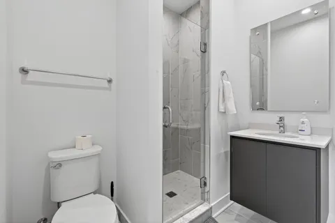 a bathroom with a sink a toilet and shower