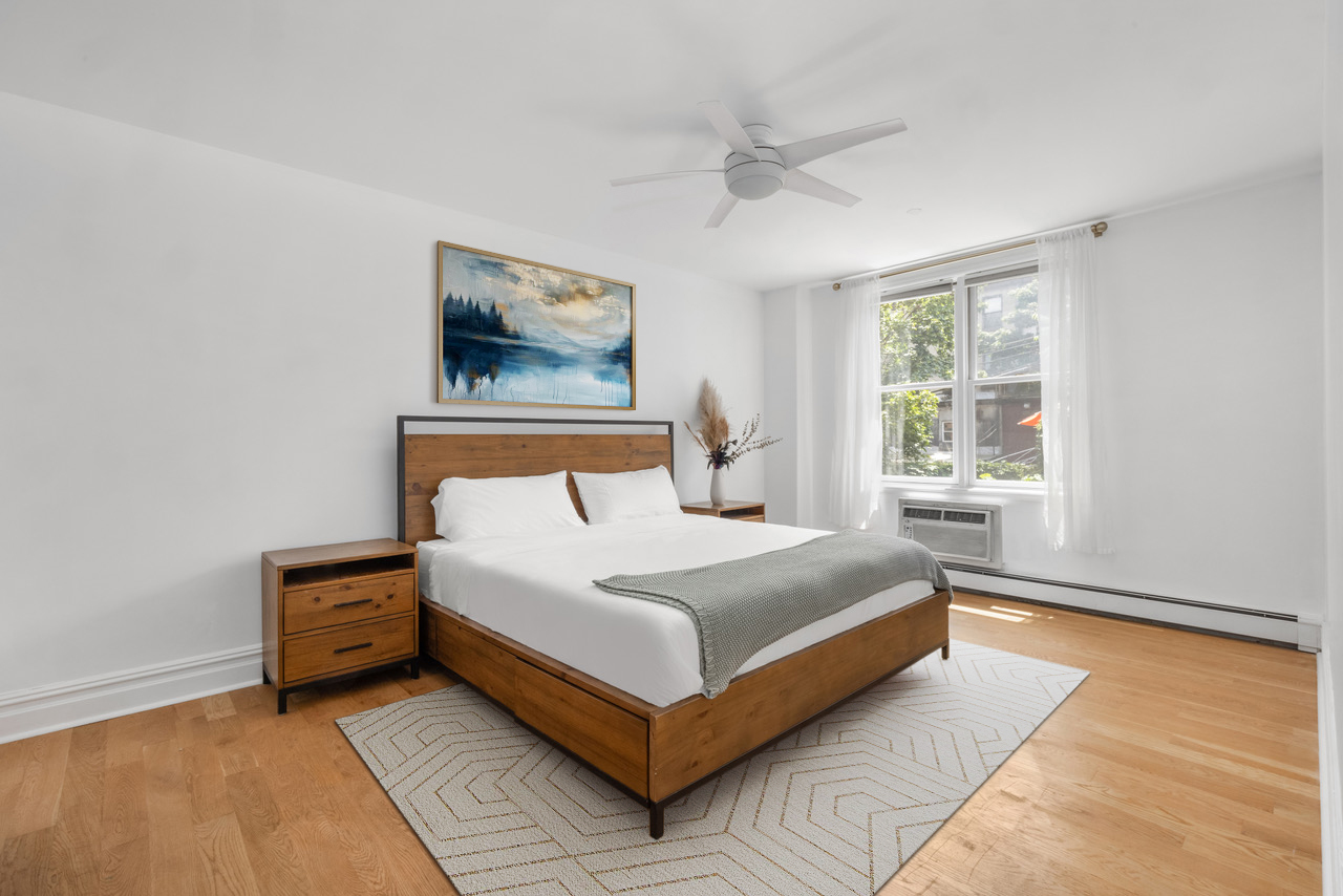 150 South 1st Street, Unit 2K Brooklyn, NY 11211 - Photo 6 of 12 a bedroom with a bed lamp and a window