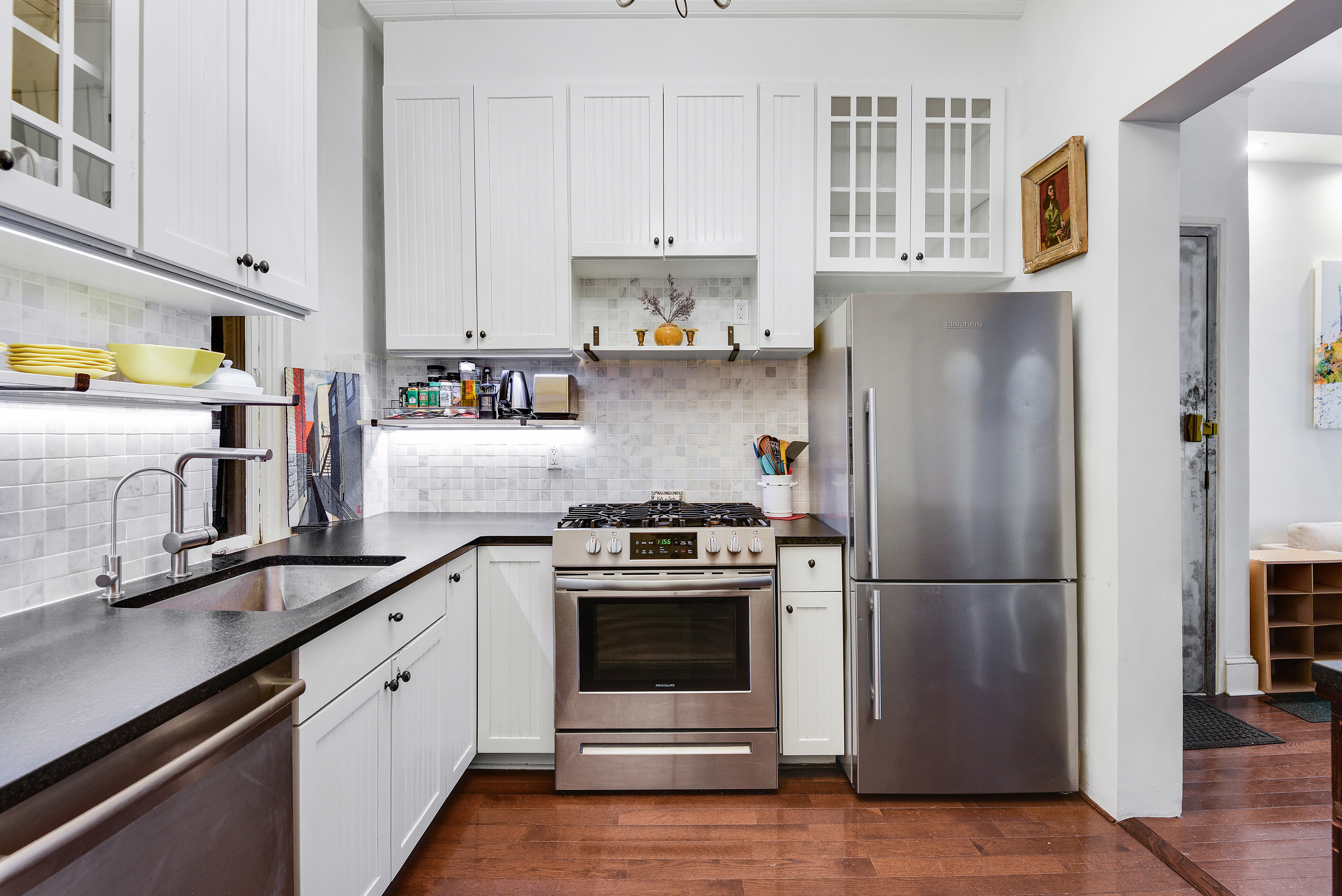 436 East 66th Street, Unit 1W Manhattan, NY 10065 - Photo 8 of 19 a kitchen with stainless steel appliances granite countertop a refrigerator stove and sink