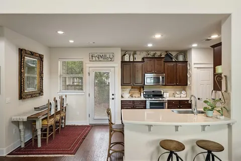 a kitchen with stainless steel appliances granite countertop a stove a sink and a microwave