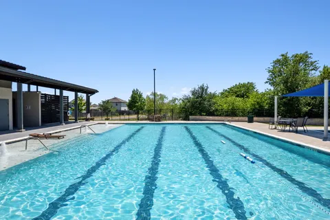 a view of backyard with swimming pool and seating space