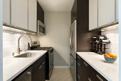 a kitchen with stainless steel appliances a sink a stove and cabinets