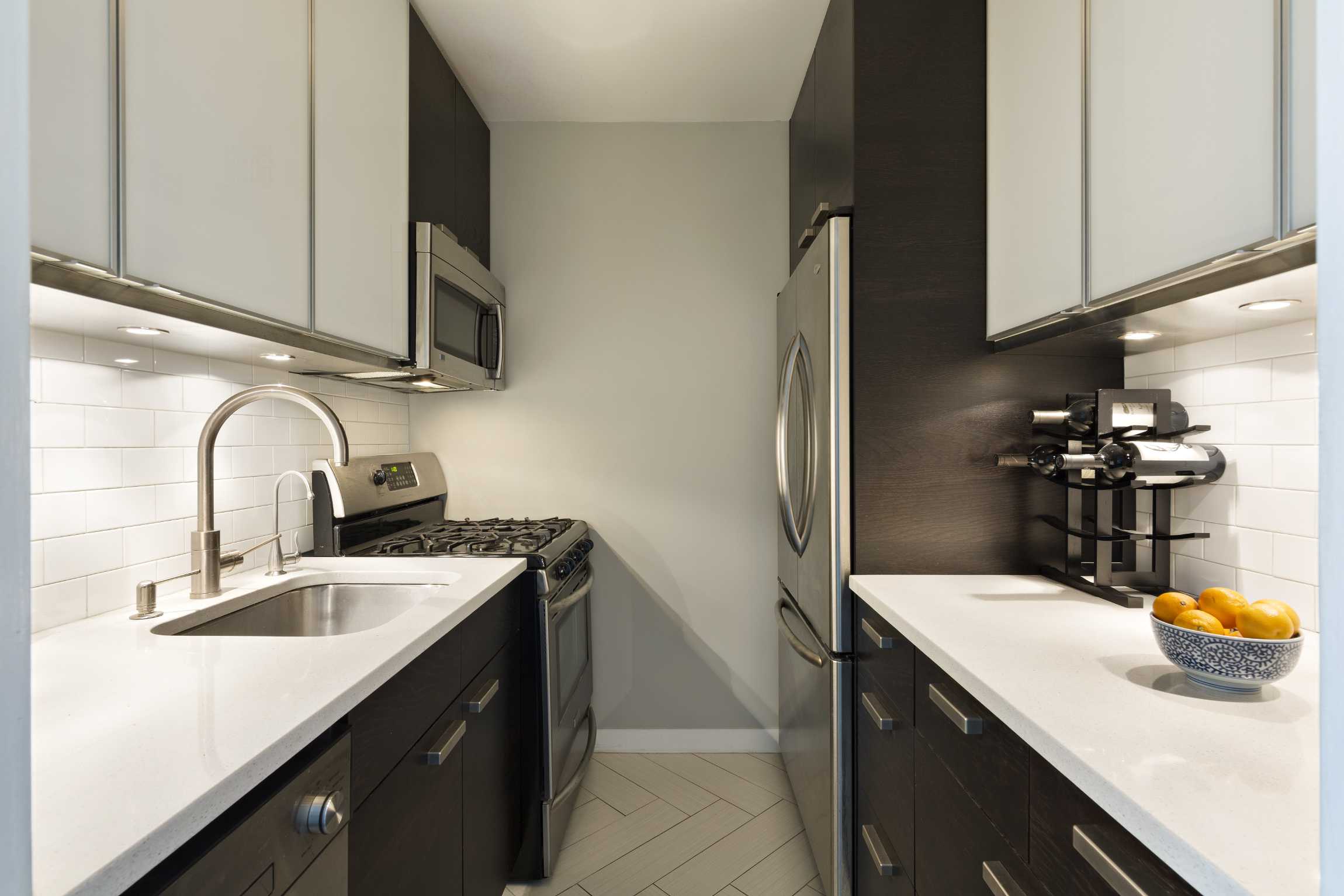 101 West 12th Street, Unit 6L Manhattan, NY 10011 - Photo 4 of 11 a kitchen with stainless steel appliances a sink a stove and cabinets