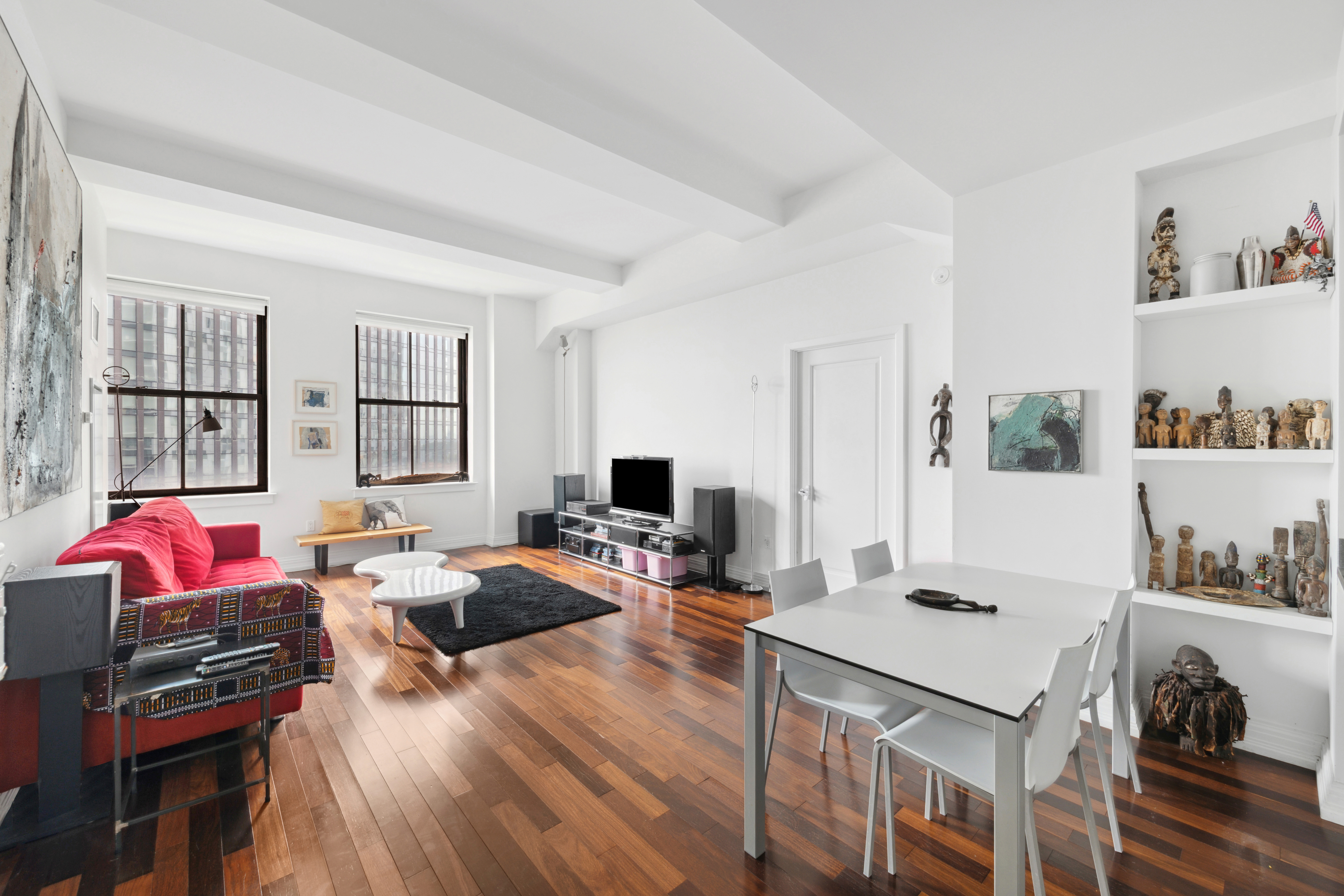 a living room with furniture a flat screen tv and a table