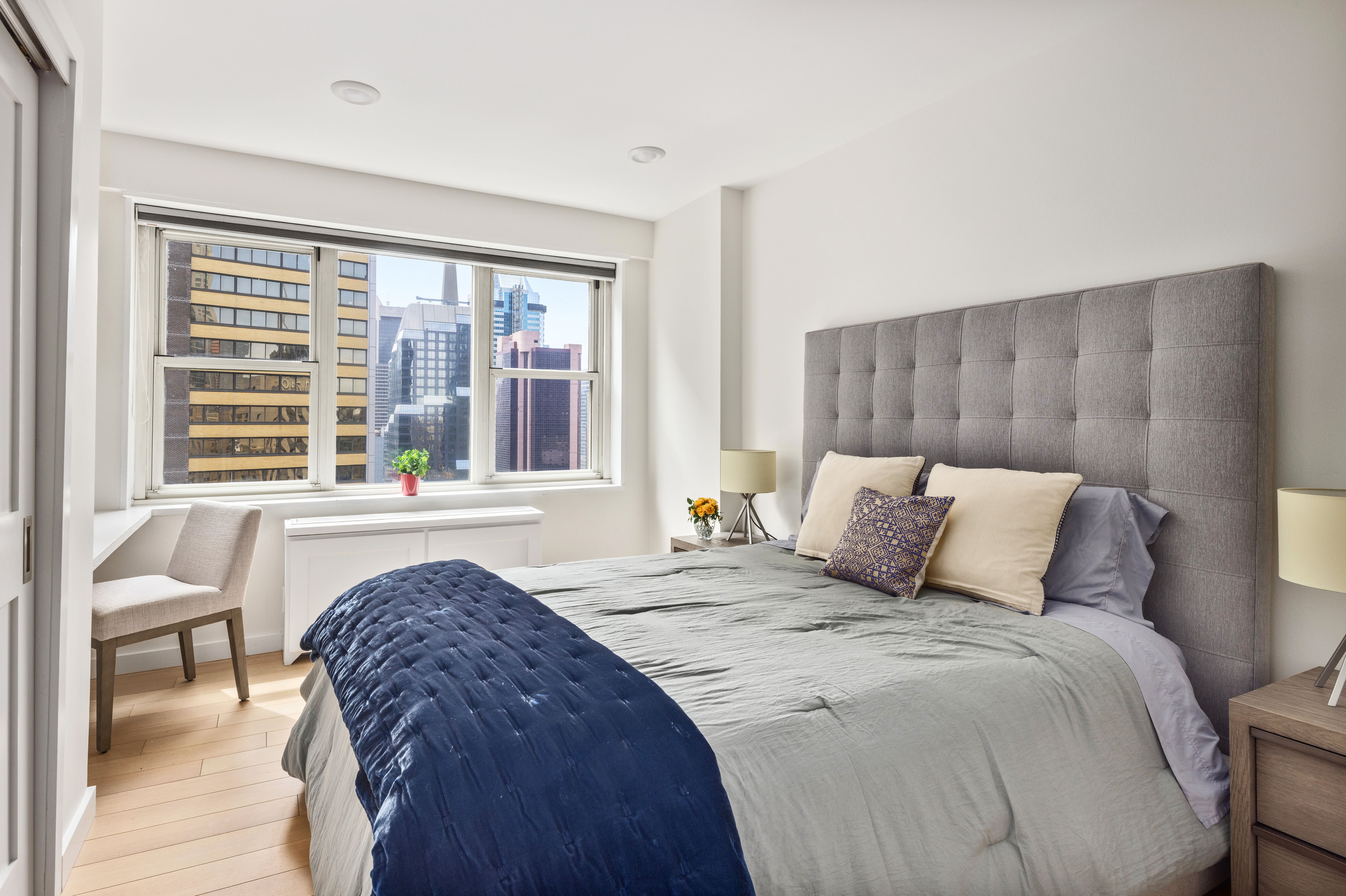 159 West 53rd Street, Unit 34E Manhattan, NY 10019 - Photo 10 of 15 a spacious bedroom with a bed and a large window