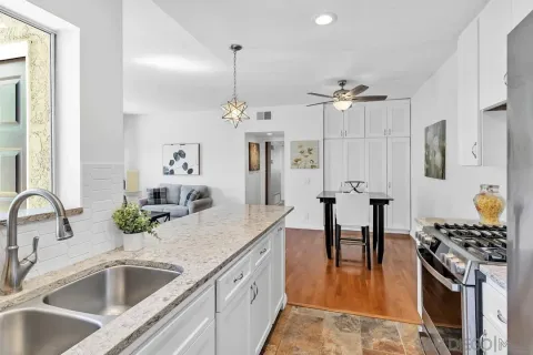 a kitchen with stainless steel appliances kitchen island granite countertop a sink and refrigerator