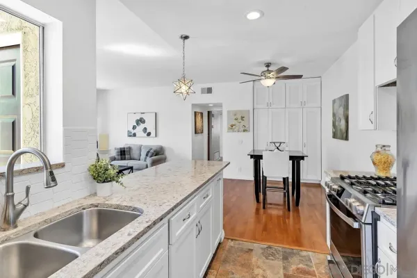 a kitchen with stainless steel appliances kitchen island granite countertop a sink and refrigerator