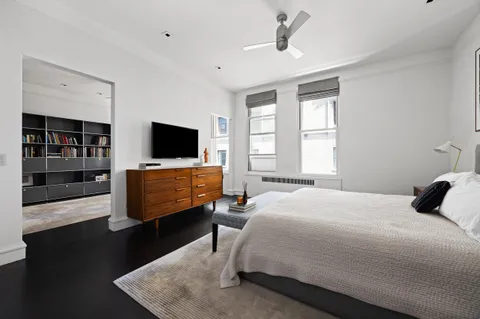 a bedroom with bed tv and window